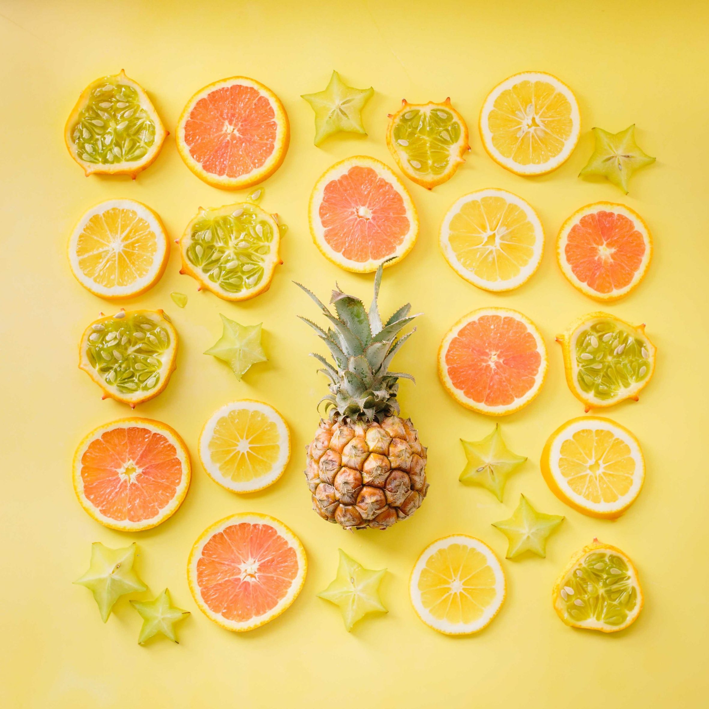 pineapple surrounded by citrus fruits